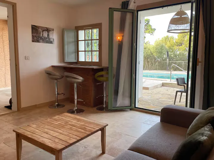 Villa living room opening onto the outdoor terrace, pool and bar